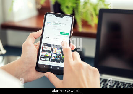 WROCLAW, POLAND - JULY 31th, 2019: Woman installs Netflix application on the Xiaomi A2 smartphone. Amazon Prime Video, is an American Internet video o Stock Photo