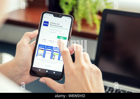 WROCLAW, POLAND - JULY 31th, 2019: Woman installs Netflix application on the Xiaomi A2 smartphone. Booking.com is a travel fare aggregator website and Stock Photo