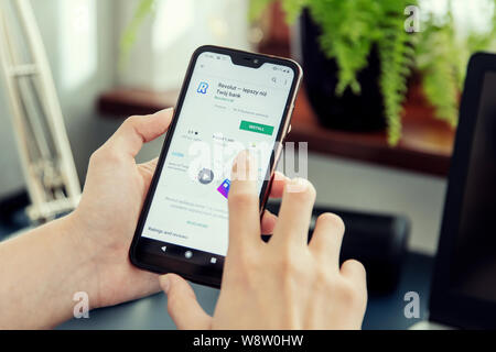 WROCLAW, POLAND - JULY 31th, 2019: Woman installs Netflix application on the Xiaomi A2 smartphone. Revolut Ltd is a UK financial technology company th Stock Photo