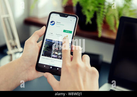 WROCLAW, POLAND - JULY 31th, 2019: Woman installs Netflix application on the Xiaomi A2 smartphone. Steam is a video game digital distribution platform Stock Photo