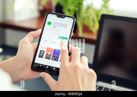 WROCLAW, POLAND - JULY 31th, 2019: Woman installs Netflix application on the Xiaomi A2 smartphone. Spotify is audio streaming platform that provides D Stock Photo