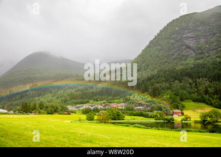 Colorful rainbow over the fields, lake and houses of Skei village, Jølster in Sogn og Fjordane county, Norway. Stock Photo