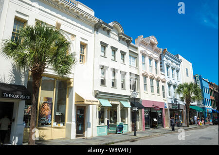 CHARLESTON, SC, USA - AUGUST 4, 2019: Pedestrians pass shops housed in colorful buildings lining the historic King Street shopping district. Stock Photo