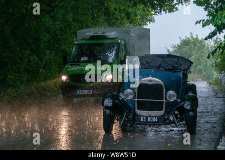 1929 Ford Roadster driver caught in heavy rain, Frome Somerset UK Stock Photo