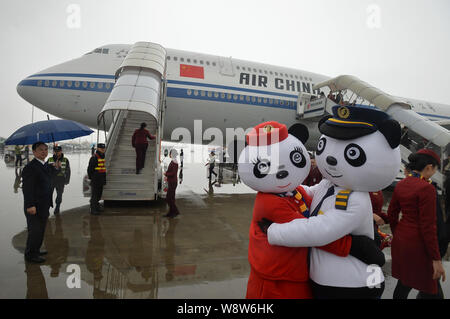--FILE--Chinese employees dressed in panda costumes pose in front of a Boeing 747-8 jet plane of Air China at the Chengdu Shuangliu International Airp Stock Photo