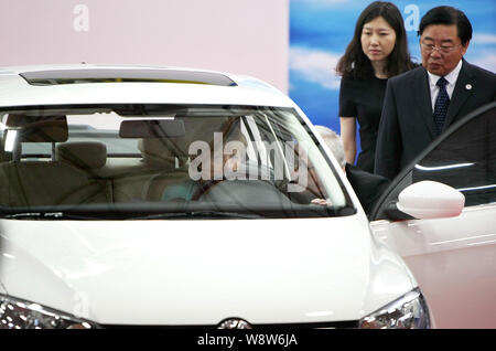 German Chancellor Angela Merkel, left, tries out an All New Jetta next to Volkswagen CEO Martin Winterkorn, second left, and FAW Group Chairman Xu Jia Stock Photo