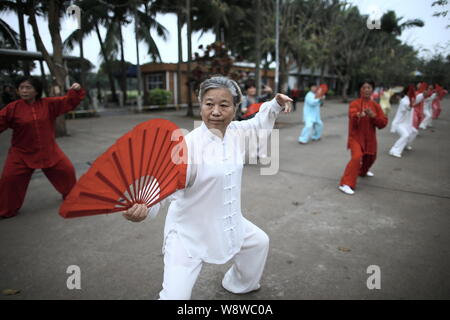 --FILE--Retired Chinese women practice Tai Chi at a park in Haikou city, south Chinas Hainan province, 25 March 2014.   For foreign visitors, it has l Stock Photo