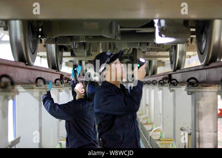 Chinese workers examine a CRH (China Railway High-speed) train at a maintenance station in Shenzhen city, south Chinas Guangdong province, 17 January Stock Photo