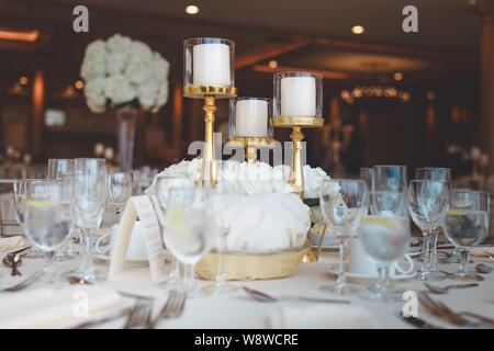 Closeup shot of white pillar candles in candelabra on a wedding table Stock Photo