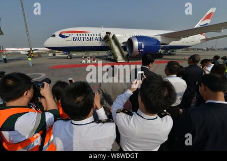 Cabin crew members and journalists take photos of a new Boeing 787 Dreamliner aircraft of British Airways at the Chengdu Shuangliu International Airpo Stock Photo