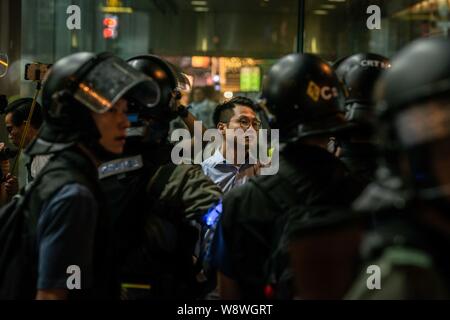 Hong Kong police arrests a civilian during the protests.Police agents and protesters clash in Nathan Road, Tsim Sha Tsui. A total of 35 people were arrested when Protesters took to the street to demonstrate against the government, they demand the complete withdraw of the extradition bill, and for the government to set up an independent inquiry into the recent clashes between protester and police. Police fired tear gas in response to another weekend of protests. Stock Photo