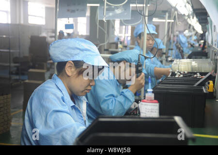 --FILE--Female Chinese workers produce projectors at a factory in Nanyang city, central Chinas Henan province, 21 August 2014.         Growth in China Stock Photo