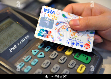 --FILE--A cashier prepares to swipe a credit card of China Citic Bank supported by China UnionPay and Visa for payment at a shop in LinAn city, east C Stock Photo