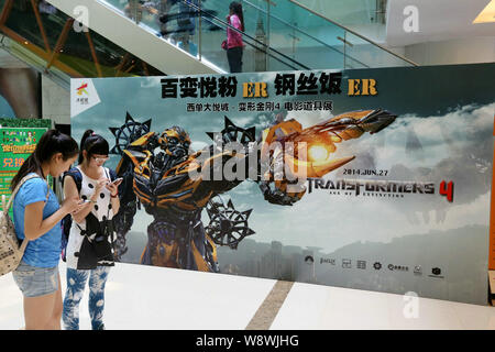 Young girls visit a prop exhibition for Hollywood movie, Transformers: Age of Extinction, at Joy City in Xidan, Beijing, China, 21 June 2014.   The st Stock Photo