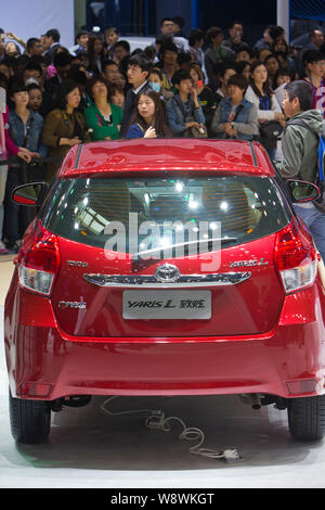 Visitors look at a YARiS L of Toyota during the 13th Beijing International Automotive Exhibition, also known as Auto China 2014, in Beijing, China, 20 Stock Photo