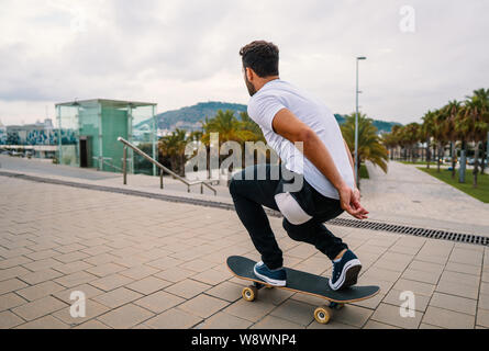 Skateboarder rides a skateboard in the modern city terrace. Stock Photo