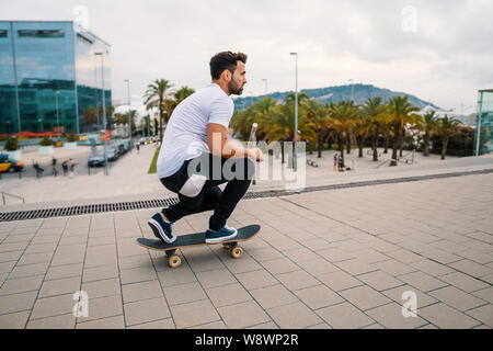 Skateboarder rides a skateboard in the modern city terrace. Stock Photo