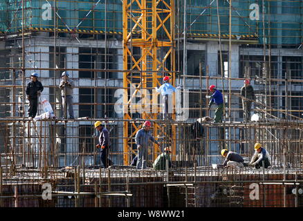 --FILE--Chinese migrant workers labor at the construction site of a government-funded residential project in Huaian city, east China's Jiangsu provinc Stock Photo