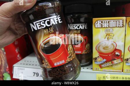 --FILE--A customer buys Nescafe coffee of Nestle at a supermarket in Xuchang city, central Chinas Henan province, 17 March 2013.   Swiss food giant Ne Stock Photo