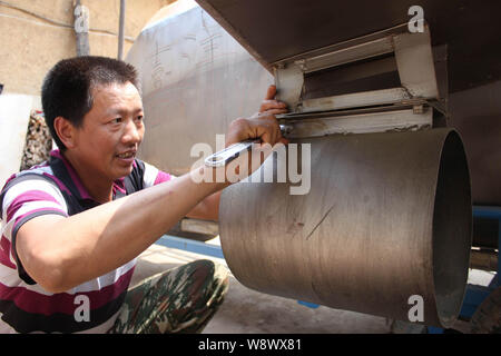 Chinese farmer Tan Yong installs a propeller on his homemade submarine at home in Lijiashan village, Danjiangkou city, central Chinas Hubei province, Stock Photo