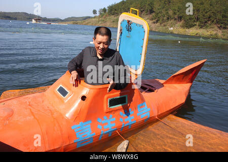 Chinese farmer Tan Yong launches his homemade orange submarine for its maiden voyage in a river in Lijiashan village, Danjiangkou city, central Chinas Stock Photo