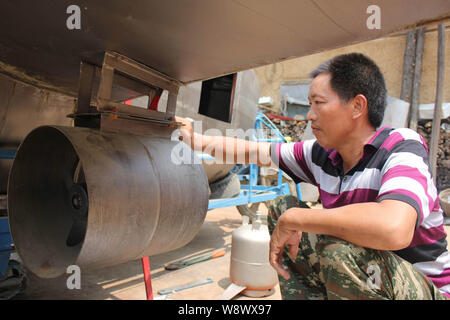 Chinese farmer Tan Yong installs a propeller on his homemade submarine at home in Lijiashan village, Danjiangkou city, central Chinas Hubei province, Stock Photo