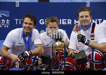 (From left) Curlers Thomas Ulsrud, Torger Nergard and Christoffer Svae pose with their champion trophy on the podium after winning the World Mens Curl Stock Photo
