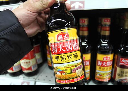 --FILE--A customer buys a bottle of Haitian mushroom dark soy sauce of Foshan Haitian Flavouring and Food Co. at a supermarket in Xuchang, central Chi Stock Photo