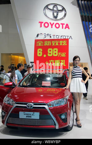--FILE--A model poses with a Toyota Yaris L during an automobile exhibition in Haikou city, south Chinas Hainan province, 12 July 2014.   More than 1, Stock Photo