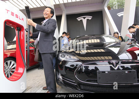 People look at Tesla Model S electric cars delivered to their owners at the sales center of Tesla in Jinqiao, Shanghai, China, 23 April 2014.   Seven Stock Photo