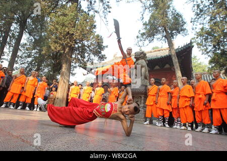 --FILE--Monks perform martial arts during a kung fu presentation at the Shaolin Temple on Mount Songshan in Dengfeng city, central Chinas Henan Provin Stock Photo