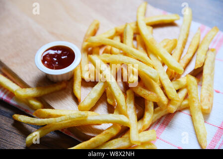 French fries on wooden board with ketchup in the dining table Stock Photo