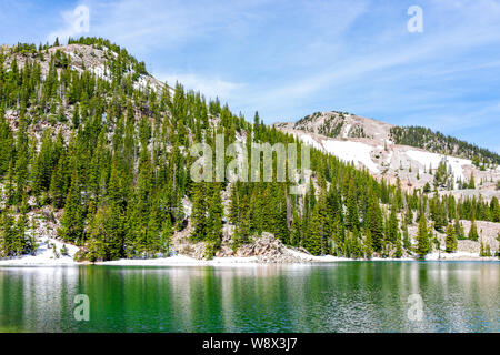 Pine tree forest and emerald green alpine lake water color on Thomas Lakes Hike in Mt Sopris, Carbondale, Colorado Stock Photo
