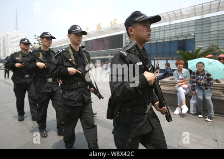 Police officers armed with guns patrol at the square of the Shanghai Railway Station in Shanghai, China, 14 May 2014.   SWAT police and other armed of Stock Photo