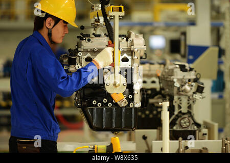 --FILE--A Chinese worker assembles an engine on the assembly line at an ...