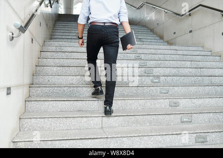 Businessman walking up the stairs Stock Photo