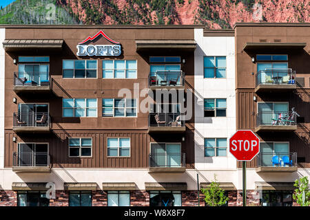 Glenwood Springs, USA - June 29, 2019: Lofts sign on new modern apartment condo buildings in Colorado town with red mountain view and stop sign Stock Photo