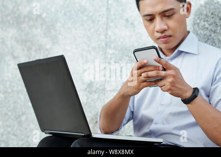 Software developer checking messenger Stock Photo