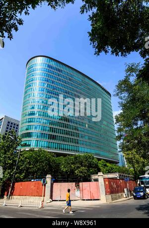 --FILE--A pedestrian walks past the headquarters building of CNOOC (China National Offshore Oil Corporation) in Beijing, China, 13 July 2014.   China Stock Photo