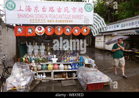 A pedestrian walks past stalls and shops at the Shanghai Dongtai Road Antique Market in Shanghai, China, 18 August 2014.   An antiques street market p Stock Photo