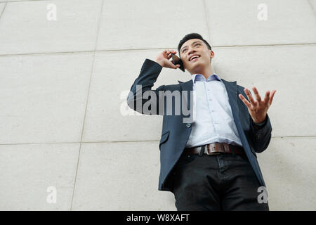 Emotional businessman talking on phone Stock Photo