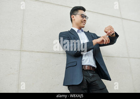 Smiling businessman checking time Stock Photo