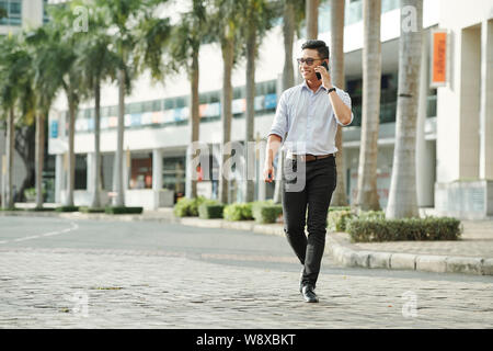 Confident man walking outdoors Stock Photo