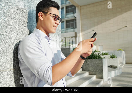 Smiling man reading text message Stock Photo