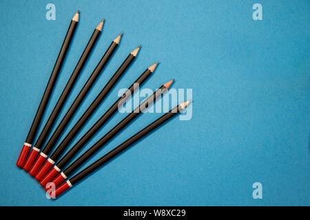 Colored red and black pencils on blue background Stock Photo