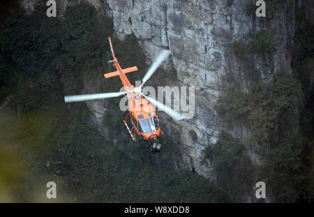 A helicopter flies to film scenes during a filming session for the movie, Transformers 4: Age of Extinction, at the Three Natural Bridges scenic spot Stock Photo