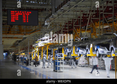 --FILE--Chinese factory workers assemble cars on the assembly line at an auto plant of Dongfeng Motor Corporation in Wuhan city, central Chinas Hubei Stock Photo