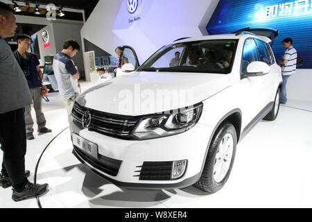 --FILE--Visitors try out or look at a New Tiguan of Shanghai Volkswagen, a joint venture between SAIC Motor and VW, during the 2014 Pudong Internation Stock Photo