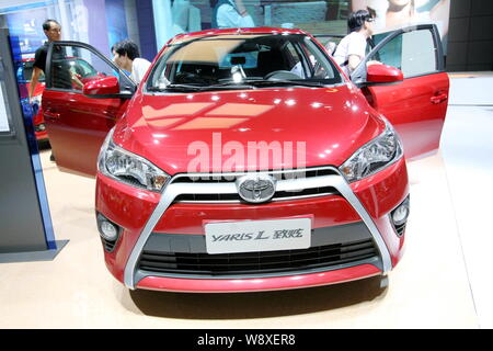 --FILE--Visitors try out a Toyota YARiS L on display during the 2014 Pudong International Automotive Exhibition, also known as Auto Pudong 2014, in Sh Stock Photo