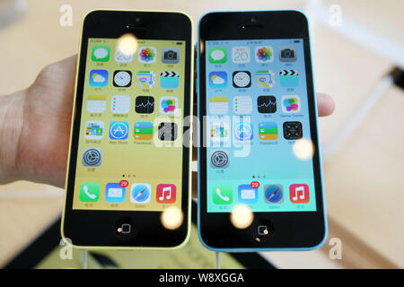 --FILE--A Chinese customer tries out iPhone 5c smartphones of Apple at an Apple store in Shanghai, China, 20 September 2013.   Apple has established i Stock Photo